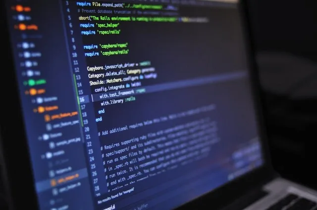 Ecran de laptop cu cod sursă în diverse limbaje de programare