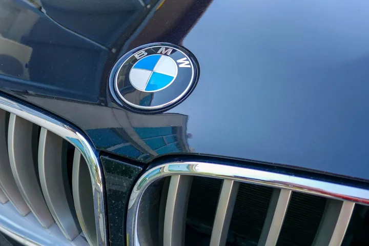 Logo-ul BMW pe o mașină, simbol al calității și inovației.