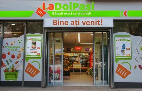Intrarea unui magazin LaDoiPași, cu produse expuse și mesaje de bun venit.
