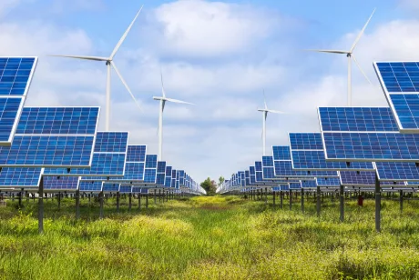 Panouri solare și turbine eoliene într-un peisaj verde.