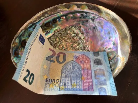 Bancnote euro așezată într-un suport decorativ strălucitor.
