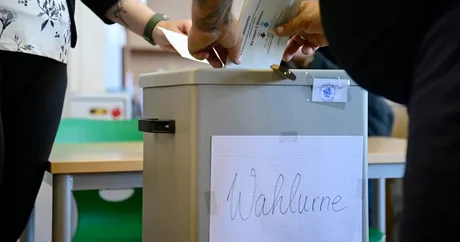 O persoană votează într-o cabină electorală în Saxonia-Anhalt.