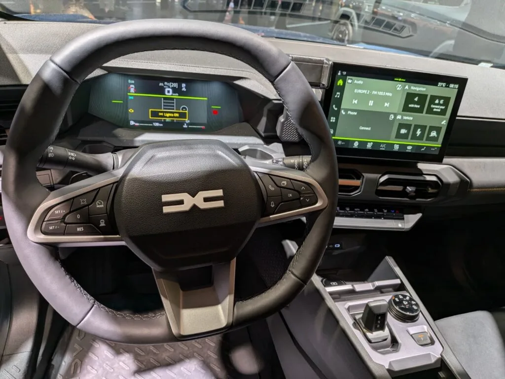 Volanul unui automobil Dacia cu display modern și funcții avansate.