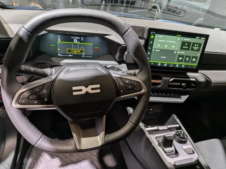 Volanul unui automobil Dacia cu display modern și funcții avansate.