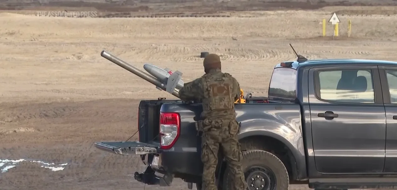 Soldat pregătind o dronă interceptoare pe un teren de antrenament.