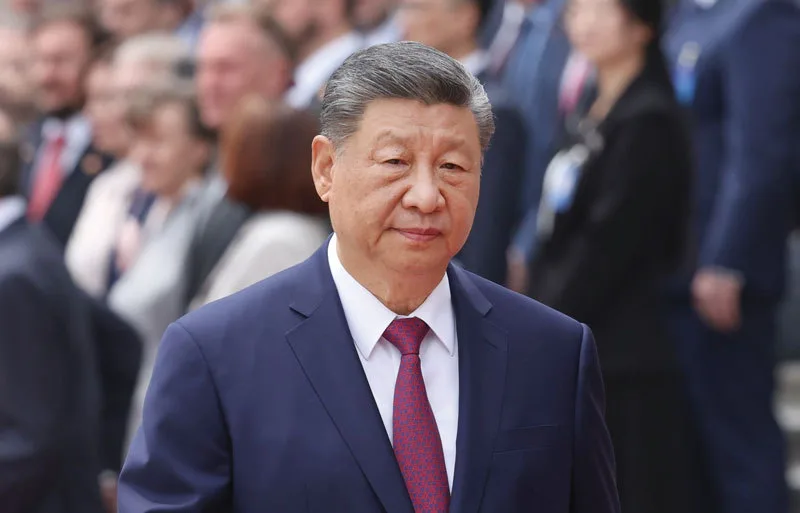 Lider chinez în timpul unei ceremonii oficiale, cu un fundal de oameni.