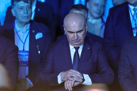 Ilie Bolojan reflectând la o întâlnire oficială, cu un aer serios.