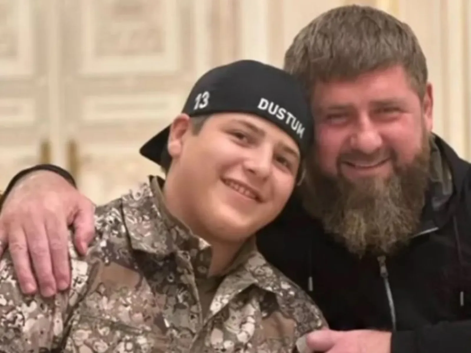 Adam Kadîrov și liderul cecen Ramzan Kadîrov zâmbind împreună într-un cadru informal.