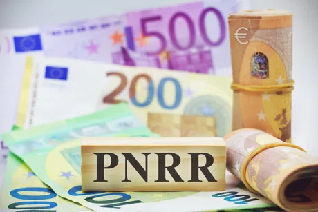 Bancnote euro și un bloc de lemn cu inscripția PNRR.