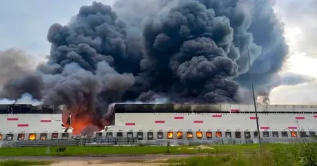Fum dens se ridică deasupra unei clădiri afectate de un incendiu.