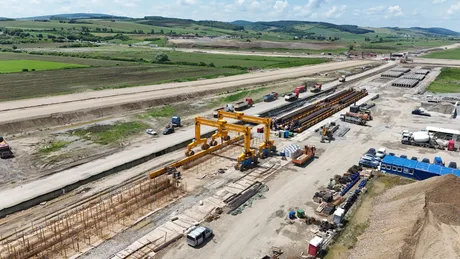 Lucrări de construcție pe lotul Joseni–Ditrău al Autostrăzii A8, cu utilaje și muncitori activi.