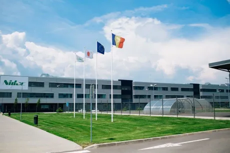 Sediul Nidec din România, cu steaguri fluturând în vânt.