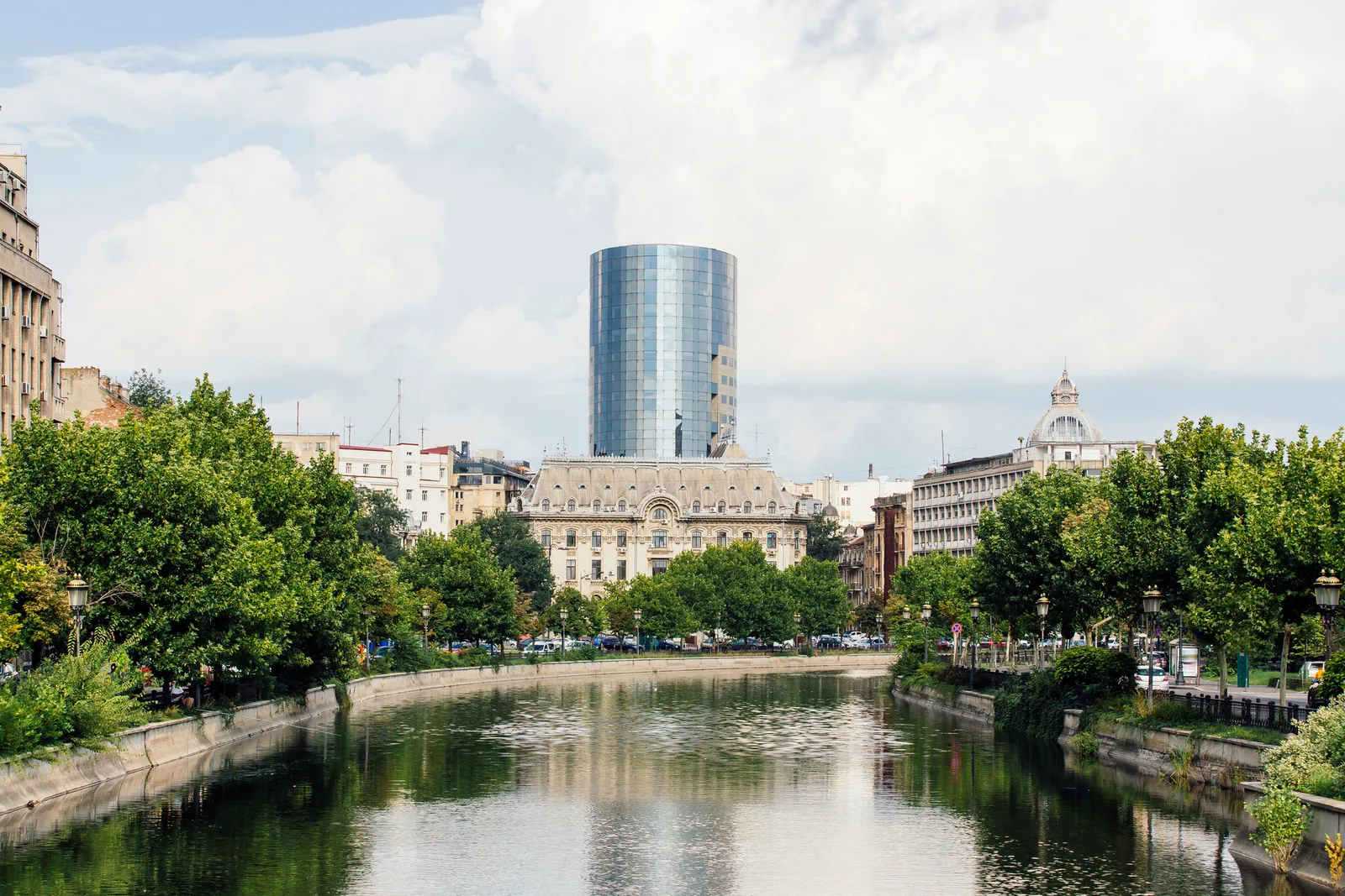 Peisaj urban din București, cu clădiri moderne și vegetație abundentă.