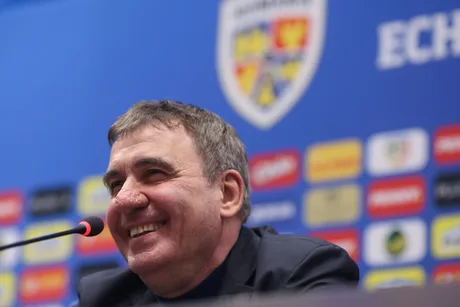 Gică Hagi zâmbind în timpul unei conferințe de presă despre naționala României.