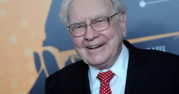 Warren Buffett zâmbește, reflectând asupra carierei sale îndelungate în afaceri.
