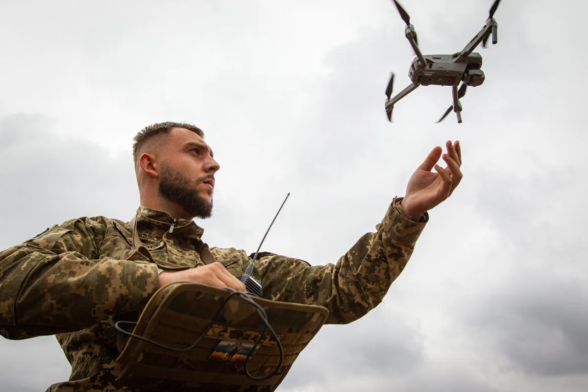 Expert ucrainean manevrând o dronă în timpul antrenamentului