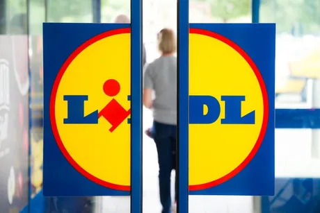 Logo-ul Lidl pe ușa unui magazin, simbol al retailului alimentar.
