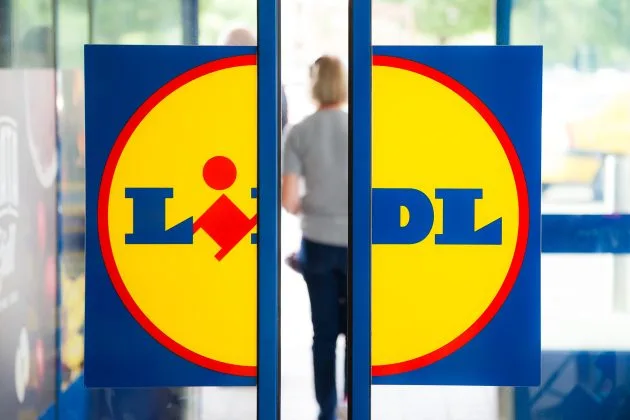 Logo-ul Lidl pe ușa unui magazin, simbol al retailului alimentar.