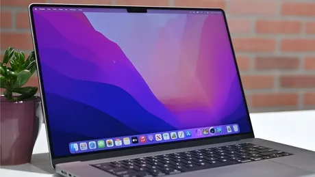 Laptop cu ecran OLED și design modern, pe un birou elegant.