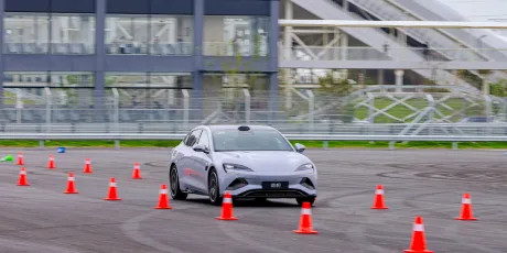 Un vehicul electric testează manevrabilitatea pe un circuit cu conuri de semnalizare.
