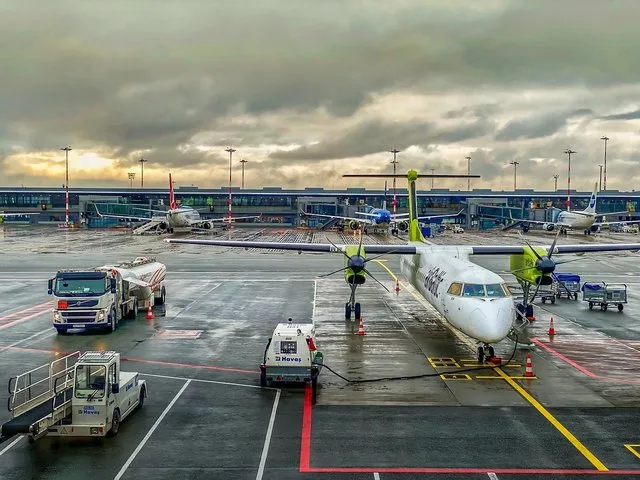 Aeroport cu avioane parcate și echipamente de realimentare.