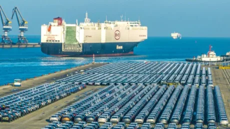 Vapoare de transport auto în port, cu mașini parcate pe țărm.