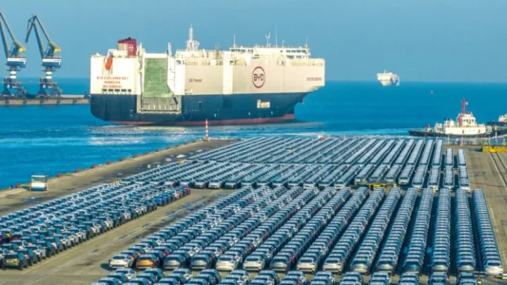 Vapoare de transport auto în port, cu mașini parcate pe țărm.