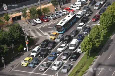 Trafic aglomerat pe o stradă din oraș, cu diverse tipuri de autovehicule.
