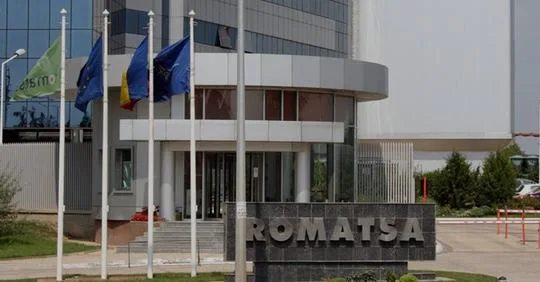 Clădirea Romatsa cu steaguri fluturând în față.