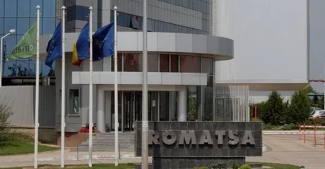 Clădirea Romatsa cu steaguri fluturând în față.