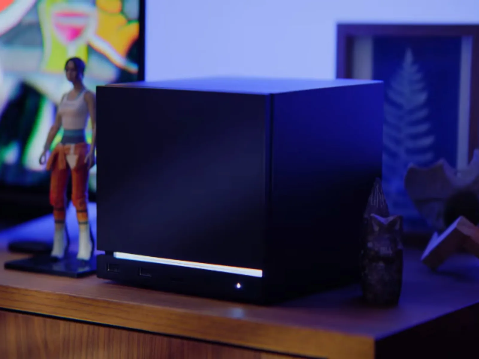 Un PC compact pentru gaming, ideal pentru living, alături de figurine decorative.