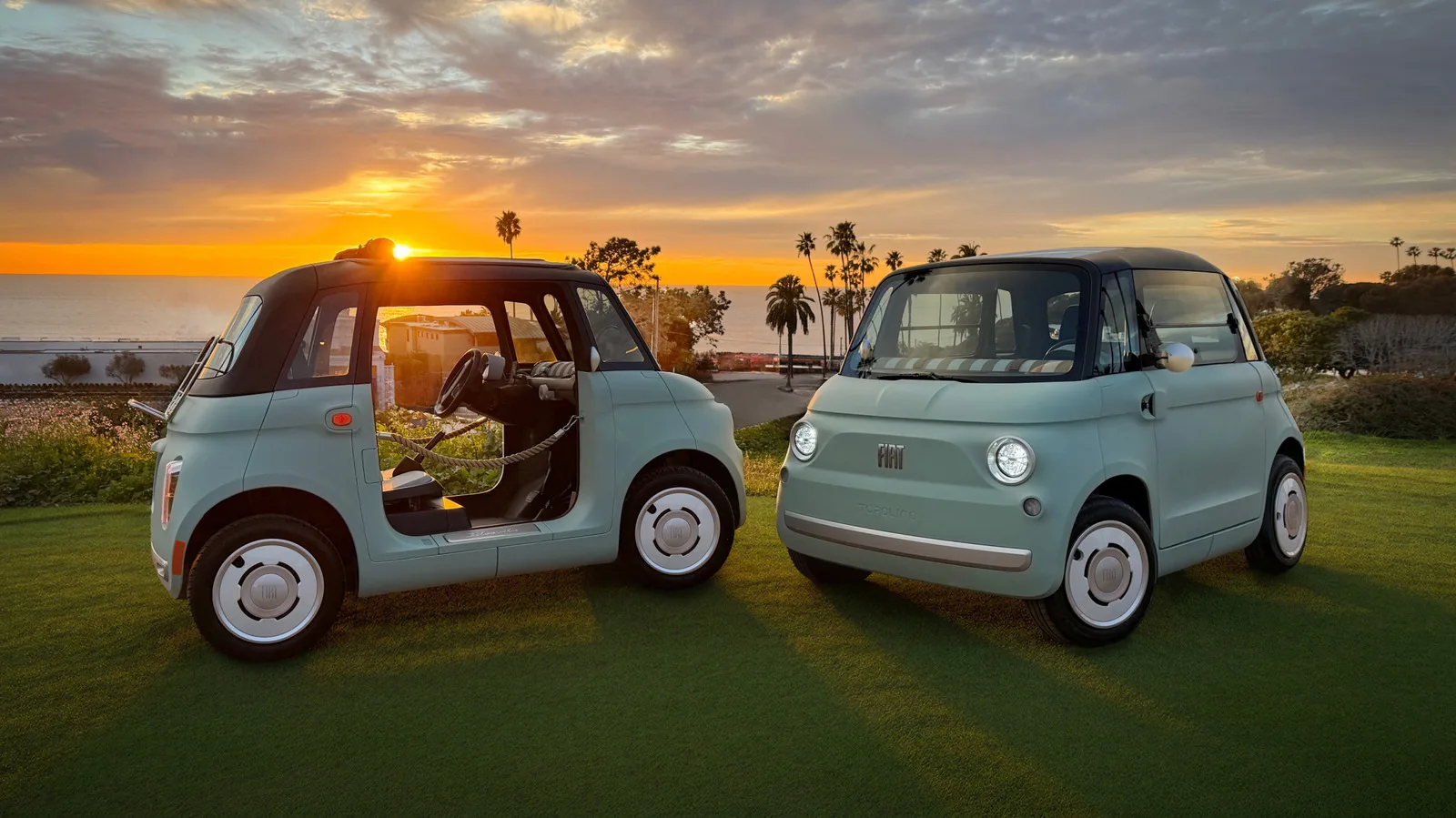 Două microvehicule electrice Fiat Topolino pe un teren verde, cu apus în fundal.