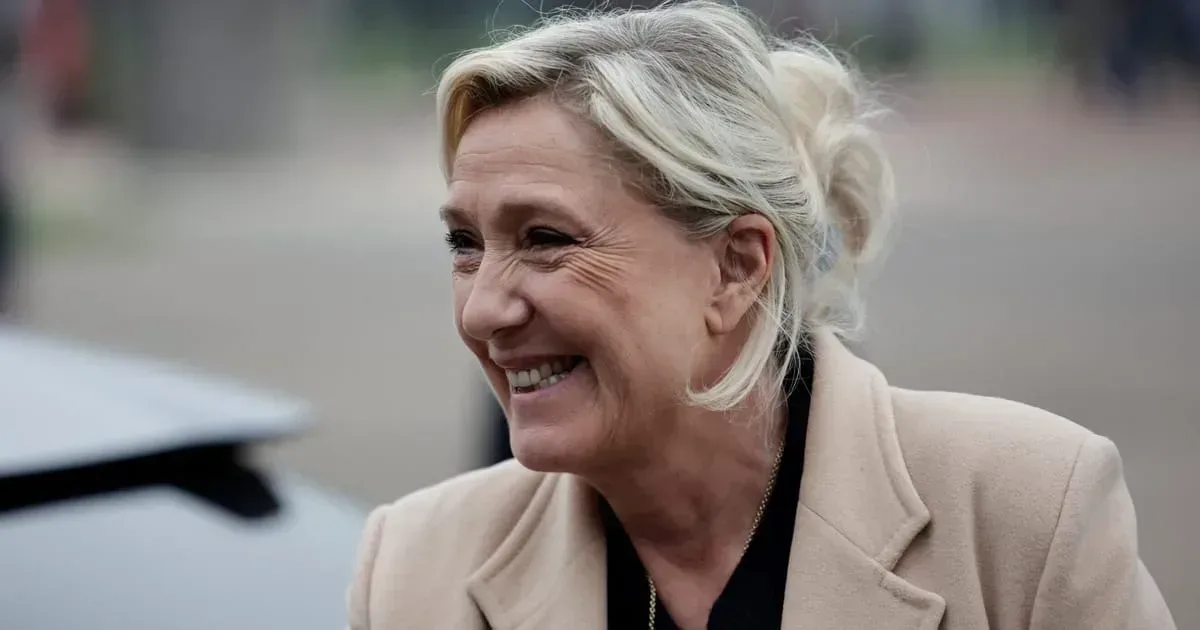 Marine Le Pen zâmbind, în fața susținătorilor, la un eveniment politic.