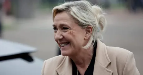 Marine Le Pen zâmbind, în fața susținătorilor, la un eveniment politic.