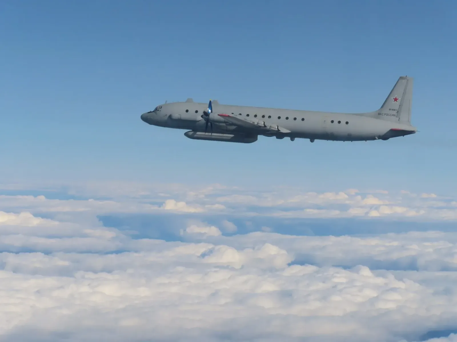 Avion Il-20 zburând deasupra norilor, în spațiul aerian internațional.