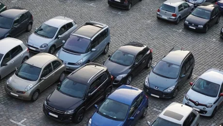Parcare cu diverse autoturisme, evidențiind diversitatea vehiculelor disponibile.