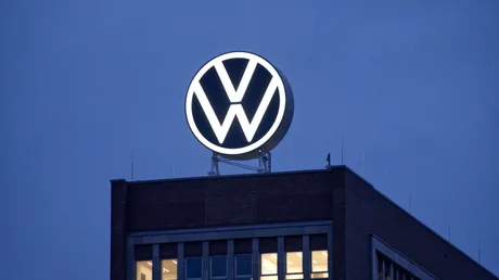 Sigla Volkswagen iluminată pe un clădire în timpul nopții.