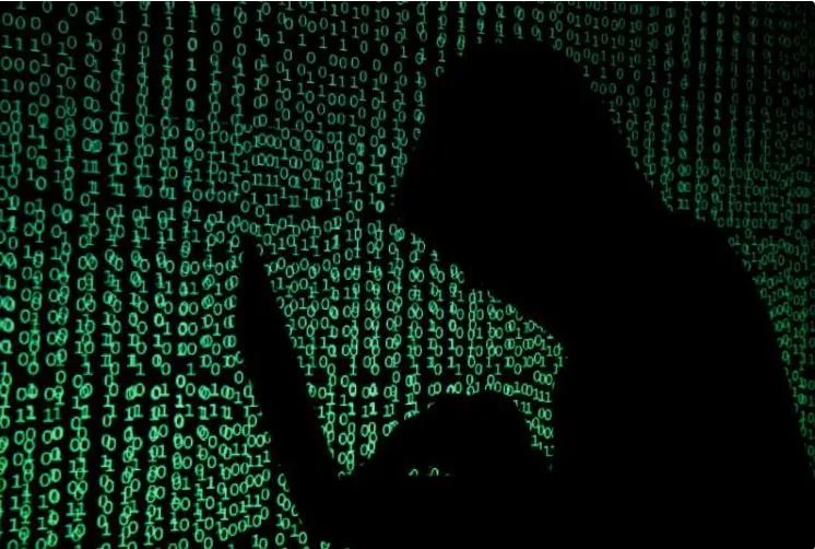 Silhouette a unei persoane lucrând pe laptop, înconjurată de cod binar verde.