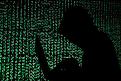 Silhouette a unei persoane lucrând pe laptop, înconjurată de cod binar verde.