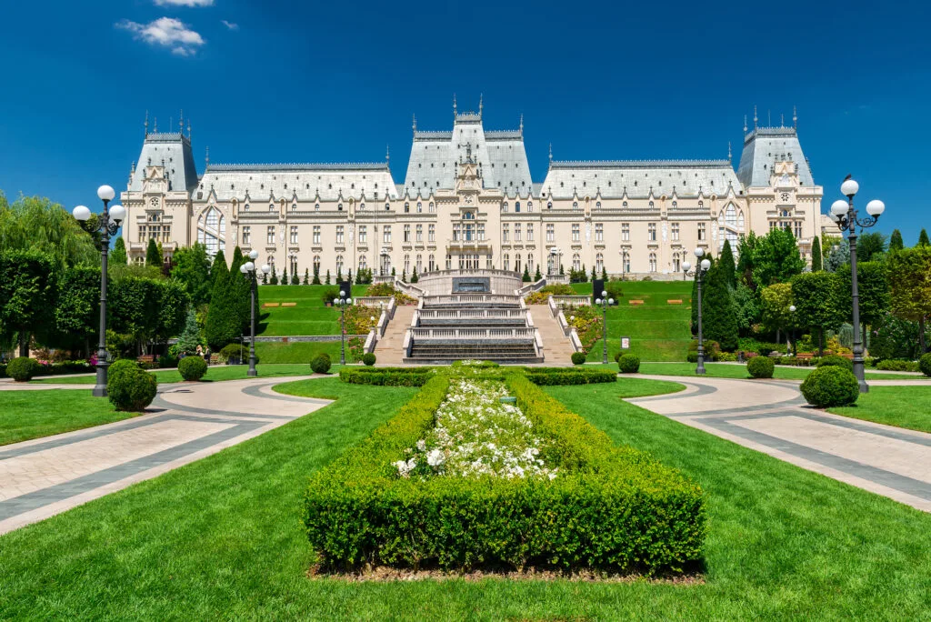 Palatul Culturii din Iași, un simbol al arhitecturii românești, înconjurat de verdeață.