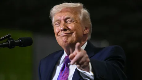 Donald Trump zâmbind și gesticulând într-un cadru informal.