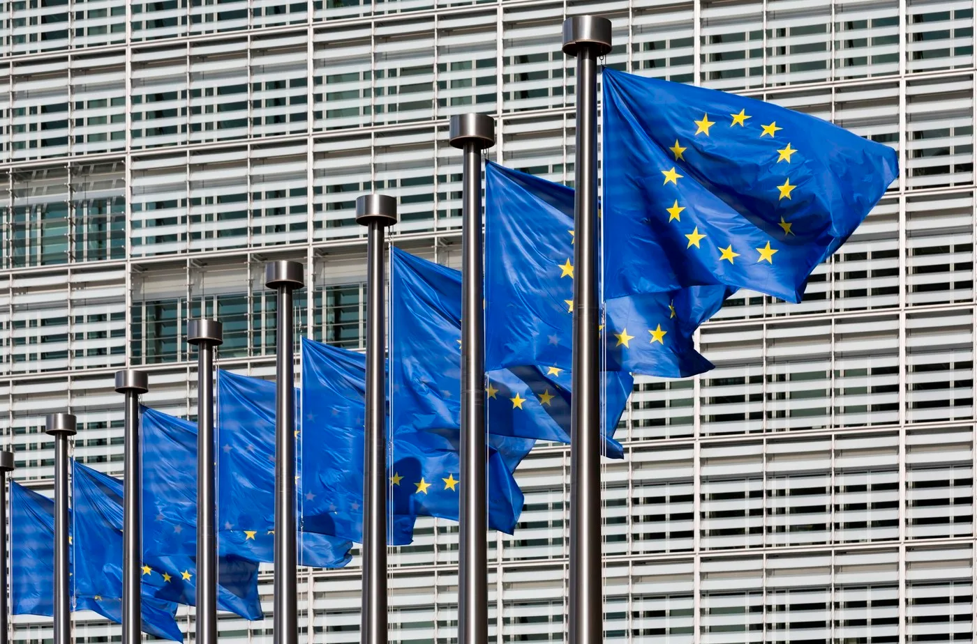 Steaguri ale Uniunii Europene fluturând în fața clădirii Comisiei Europene.