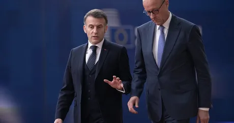 Emmanuel Macron și un oficial german discutând despre livrările de motorină.