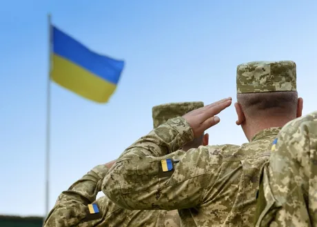 Veterani ucraineni salutând steagul național în context militar.