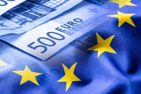 Bancnote euro pe fundalul steagului Uniunii Europene.