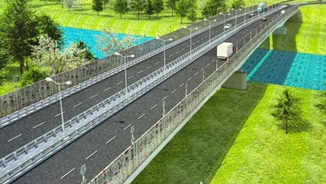 Podul Unirii peste Prut, în construcție, cu vegetație în jur și drum asfaltat.