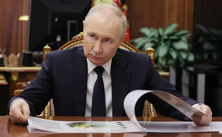 Vladimir Putin analizând documente într-un birou oficial.