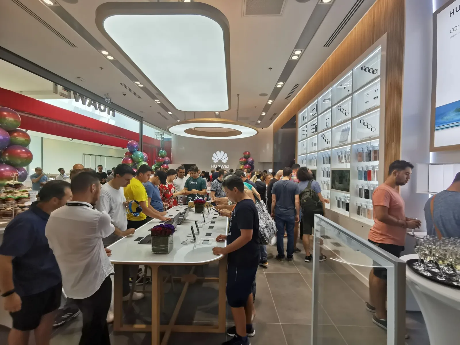 Clienți explorând produsele din magazinul Huawei Store.