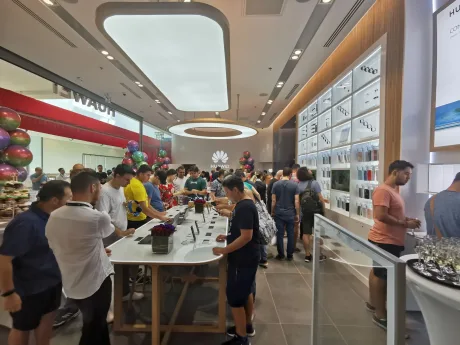 Clienți explorând produsele din magazinul Huawei Store.