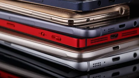 Telefoane mobile aranjate pe o masă, evidențiind cheltuieli nejustificate.